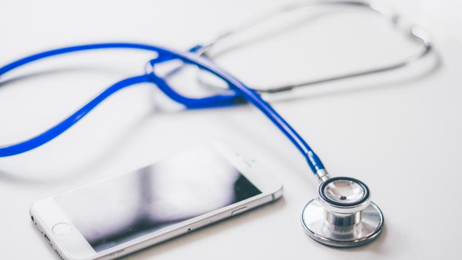 Libros de estudio, lápiz y fonendoscopio sobre una mesa